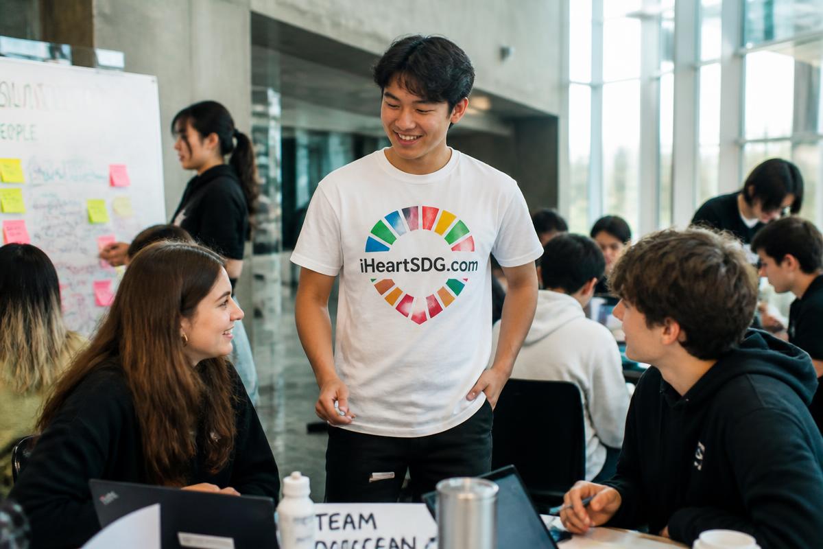 Students at a university innovation event wearing an iHeartSDG.com shirt